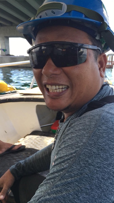 Crew member selfie, smiling near the pier with DIVER helmet